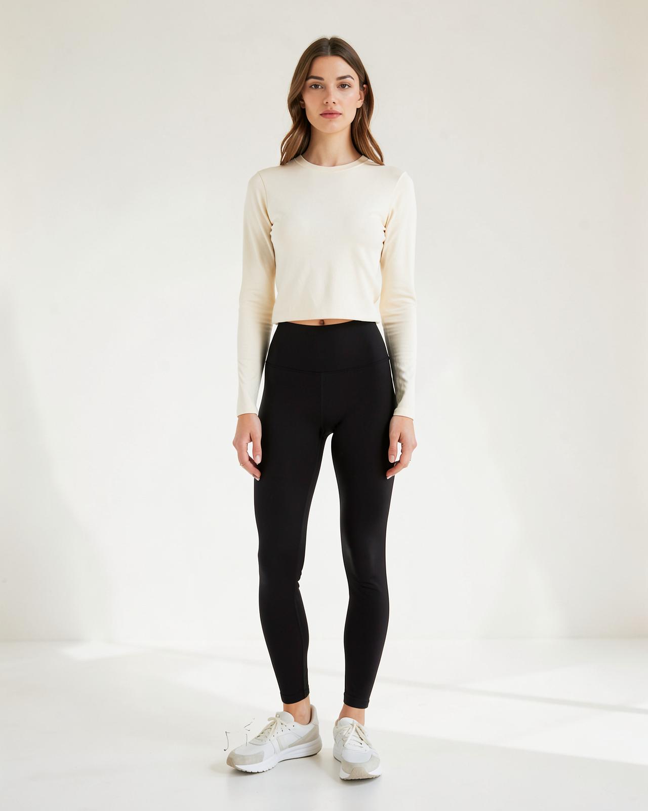 Mulher usando legging preta de cintura alta AcheiOff em estúdio claro